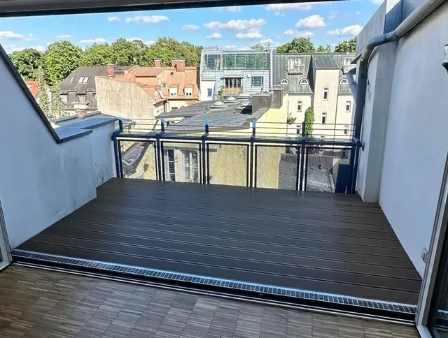 Fertig sanierte Dachterrasse mit dunklem WPC-Belag am Eingang